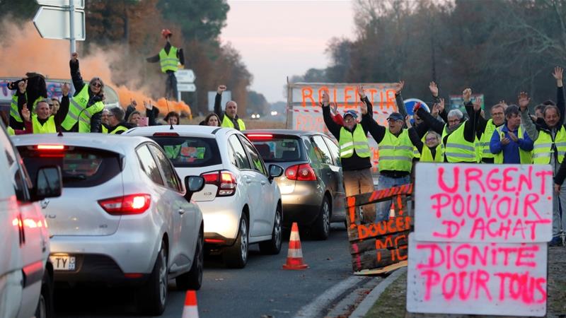 Protesters wearing yellow vests occupying a roundabout. 